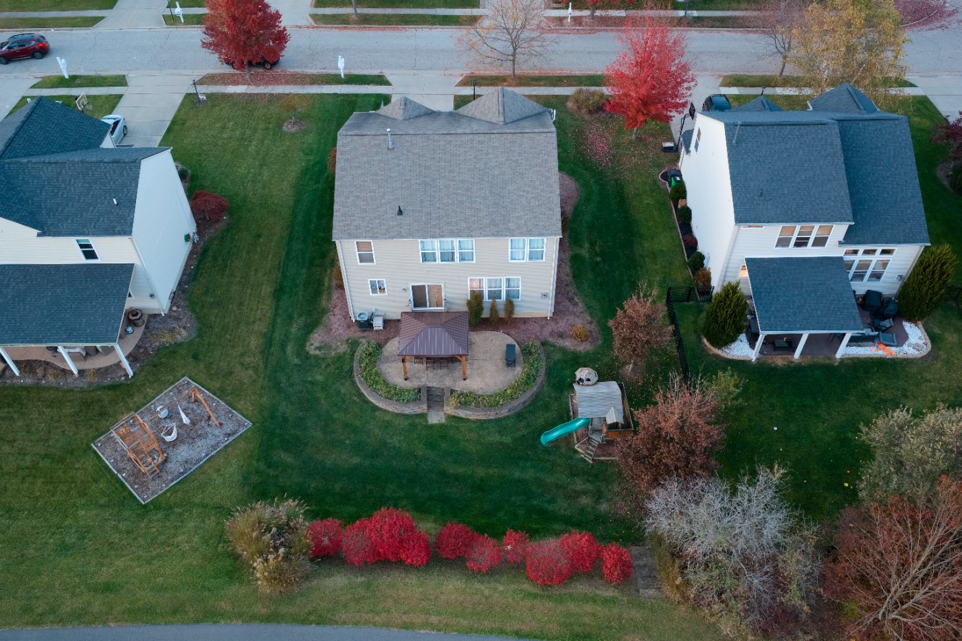 Elevated view of the back of the house with the patio, gazebo, play area and landscaped border