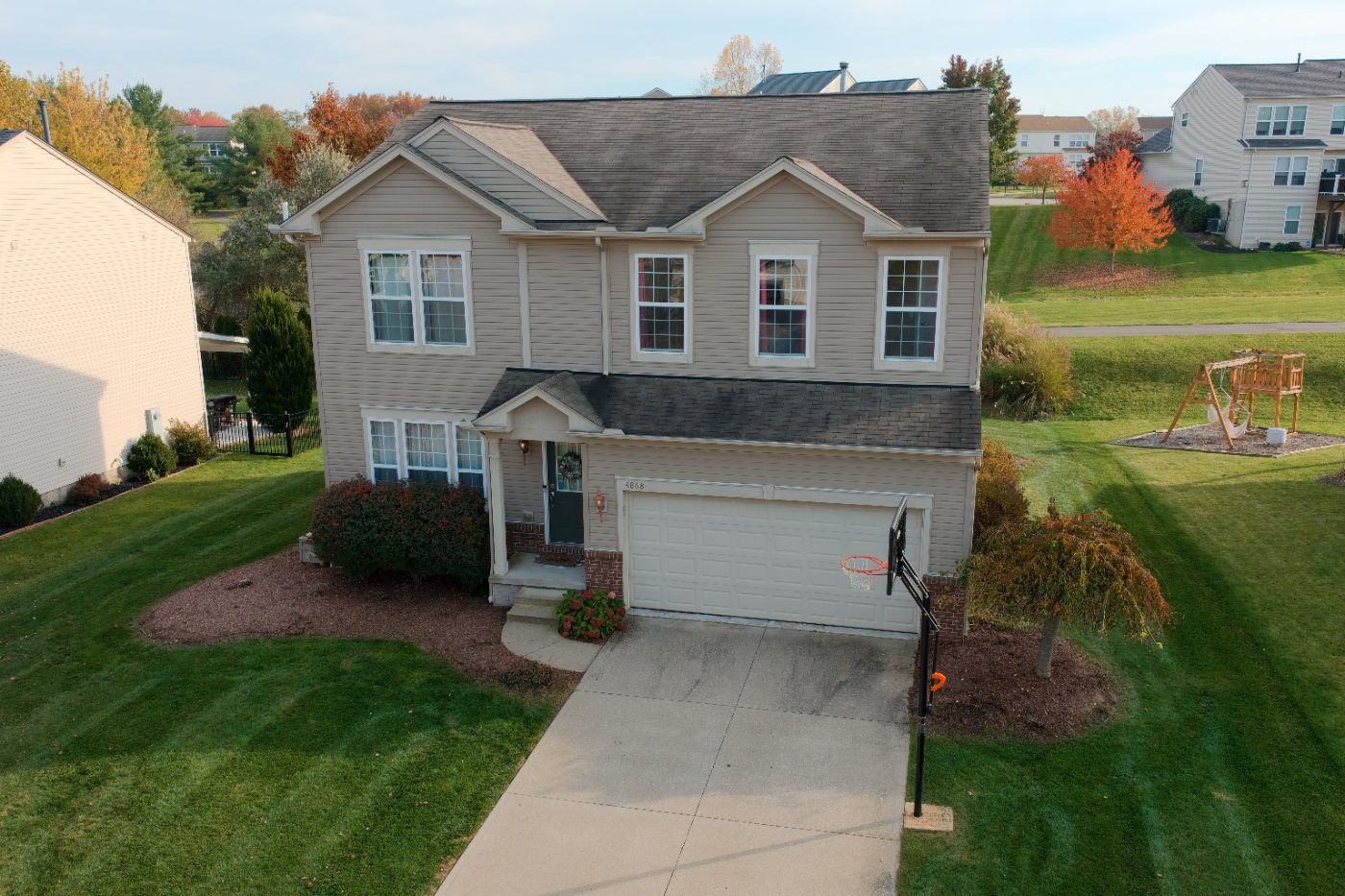 Front of the house at a low angle with the porch, garage and front lawn