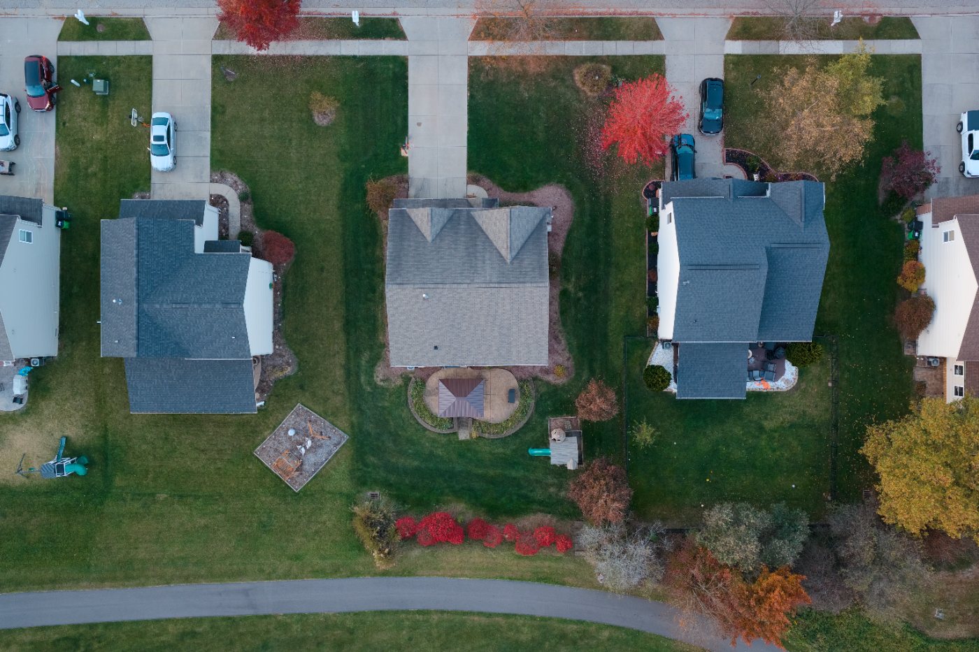 Elevated view of the house from the street side, with the driveway, side yard, back yard and walking path