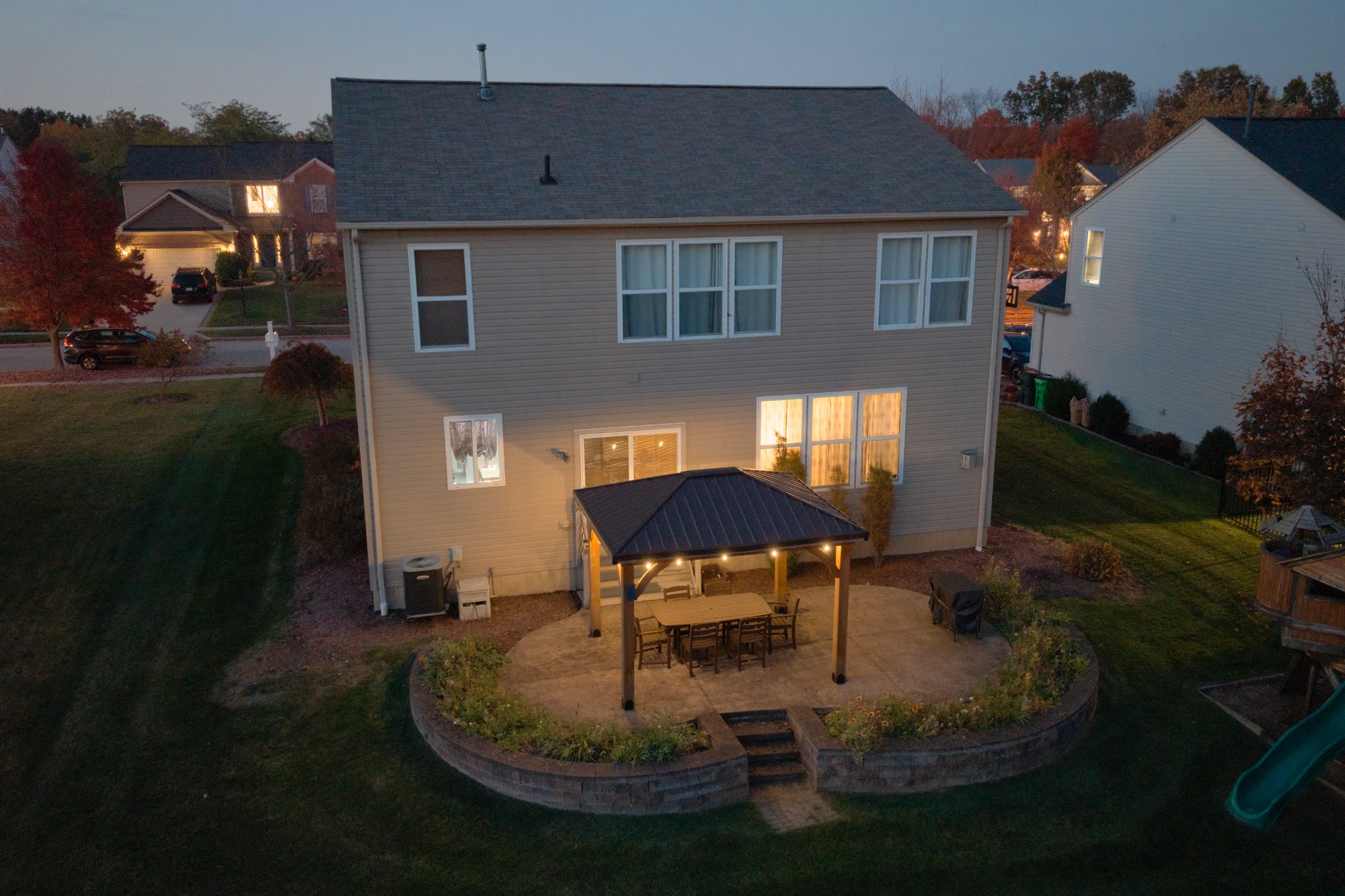 Closer twilight view of the back patio and gazebo with warm interior lights