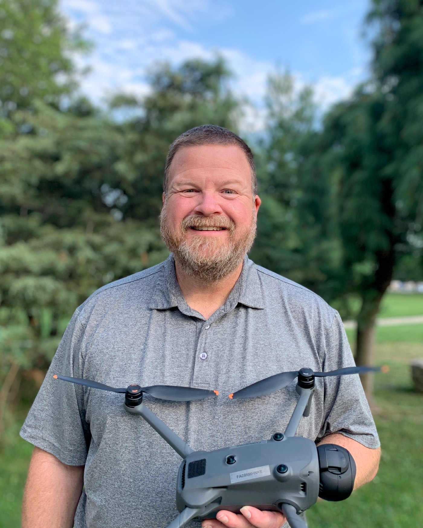 The pilot standing outdoors holding a DJI Mavic 4 Pro quadcopter